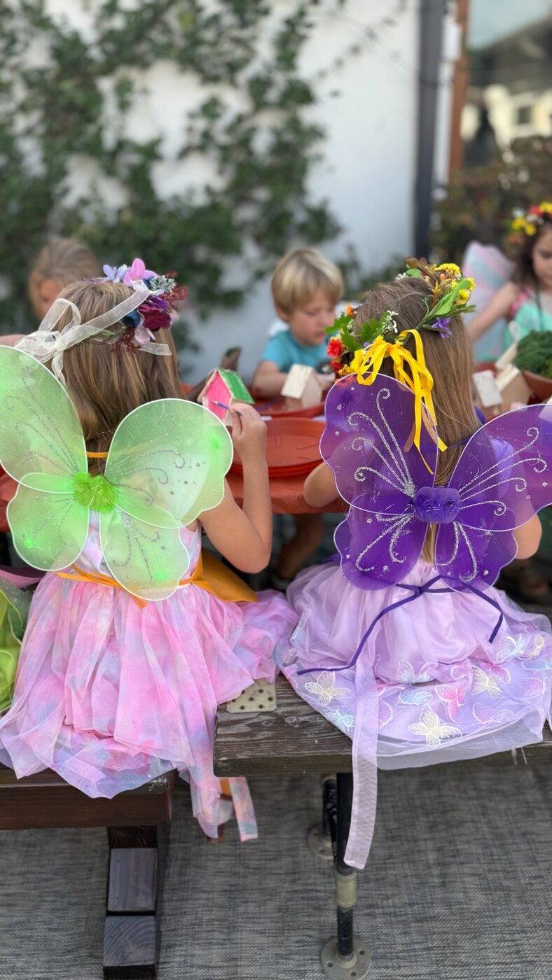 Children in fairy wings working on an activity